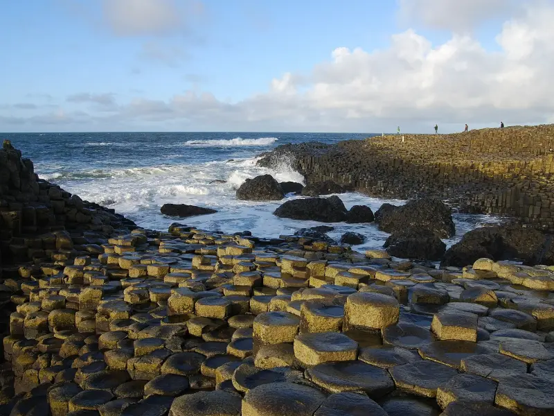 Dramatic Northern Irish coastline with the Giant's Causeway basalt columns meeting grey Atlantic waters